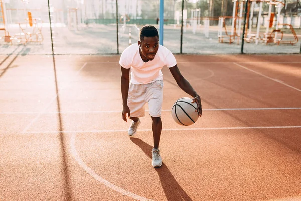 Starke junge afrikanische Sportler im Stadion unter freiem Himmel, um Basketball zu spielen. — Stockfoto
