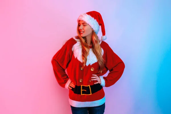 Attraente giovane donna in cappello Santa posa sullo sfondo di luci al neon — Foto Stock