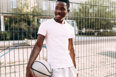 Stadyumda basketbol topu olan güçlü bir Afrikalı Amerikalı.