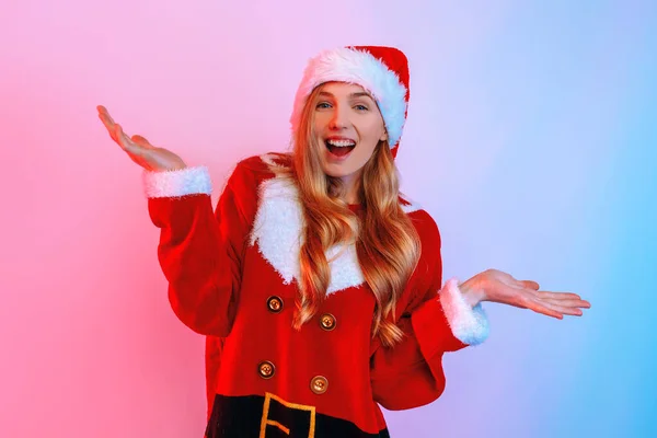 Retrato de menina confusa usando chapéu de Papai Noel mostrando gesto vago isolado no fundo — Fotografia de Stock