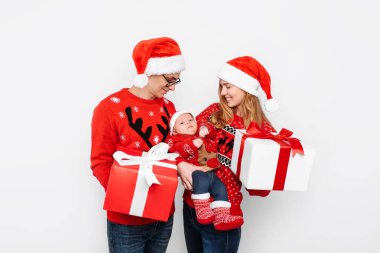 Mutlu aile, anne, baba ve küçük bebek. Beyaz arka planda izole edilmiş Noel hediyeleri.