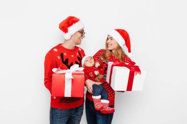 Mutlu aile, anne, baba ve küçük bebek. Beyaz arka planda izole edilmiş Noel hediyeleri.