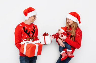 Mutlu aile, baba, anne ve küçük bebek, Noel 'i kutlayın ve beyaz arka planda Noel hediyeleri verin.