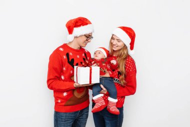 Mutlu aile, baba, anne ve küçük bebek, Noel 'i kutlayın ve beyaz arka planda Noel hediyeleri verin.