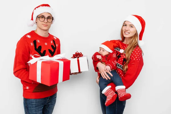 Família feliz, mãe, pai e bebê pequeno com presentes de Natal isolados no fundo branco — Fotografia de Stock