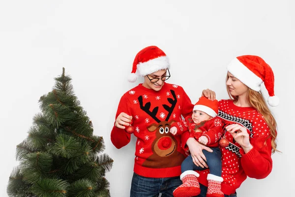 Szczęśliwa rodzina w Boże Narodzenie kapelusze, mama tata i małe dziecko świętować Boże Narodzenie i ozdobić choinkę. — Zdjęcie stockowe
