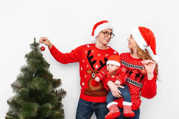 Família feliz em chapéus de Natal, mamãe pai e criança comemorar o Natal e decorar a árvore de Natal . — Fotografia de Stock