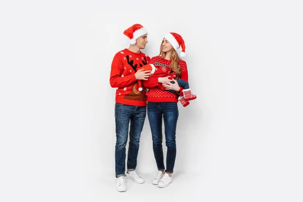 Família feliz em chapéus de Papai Noel, mãe pai e bebê pequeno comemorar o Natal — Fotografia de Stock