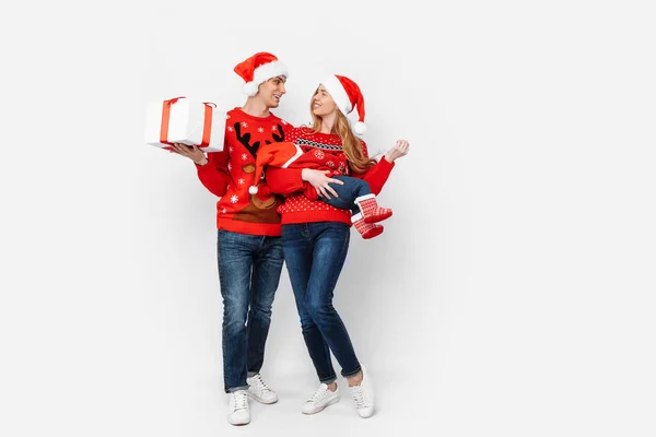 Família feliz, mãe, pai e bebê pequeno com presentes de Natal isolados no fundo branco — Fotografia de Stock