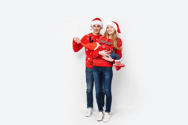 Gelukkig gezin in Santa hoeden, mama papa en kleine baby vieren Kerstmis — Stockfoto