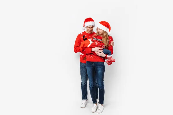 Gelukkig gezin in Santa hoeden, mama papa en kleine baby vieren Kerstmis — Stockfoto