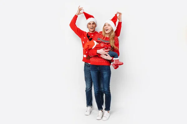 Gelukkig gezin in Santa hoeden, mama papa en kleine baby vieren Kerstmis — Stockfoto