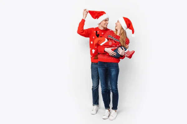 Família feliz em chapéus de Papai Noel, mãe pai e bebê pequeno comemorar o Natal — Fotografia de Stock