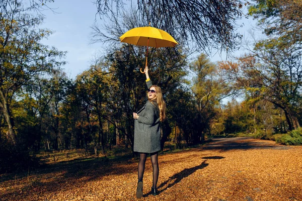 Stilvolle junge Frau geht im Herbstpark spazieren — Stockfoto