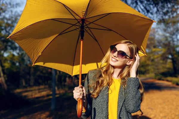 노란색 우산을 두른 소녀, 노란색 잎이 달린 가을 시간 이 있는 공원에서 — 스톡 사진