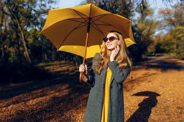 Ragazza, con ombrello giallo, nel Parco con foglie gialle, ora d'autunno — Foto Stock