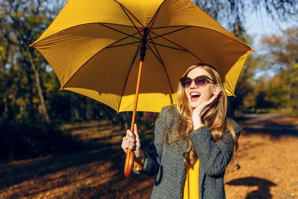 Mädchen mit gelbem Regenschirm, im Park mit gelben Blättern, Herbstzeit — Stockfoto