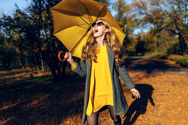 Счастливая девочка в хорошем настроении бегает по парку и наслаждается осенью
