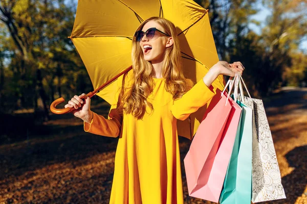 Gyönyörű, elegáns fiatal nő, őszi ruhákban, táskákkal vásárlás után — Stock Fotó