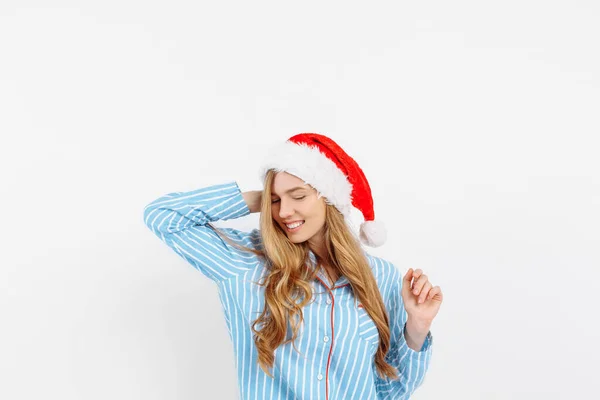 Piękna młoda dziewczyna, w piżamie i kapeluszu Świętego Mikołaja, w Wigilię — Zdjęcie stockowe