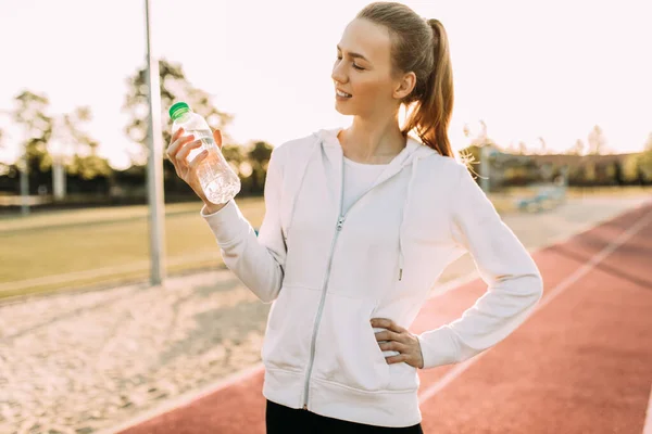 Schöne Athletische Läuferin Steht Draußen Stadion Und Hält Eine Wasserflasche — Stockfoto
