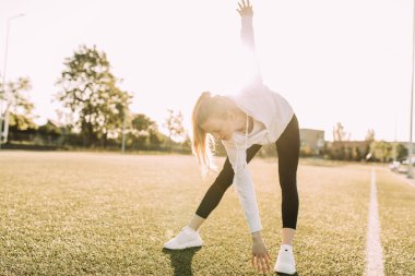 Çekici zayıf atletik kadın açık havada esneme egzersizleri yapıyor. Spor, koronavirüs, karantina