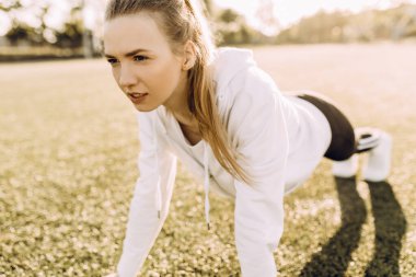 Mükemmel tahta. Spor kıyafetli genç bir kadın, dışarıda dikilirken bir kalas yapıyor.