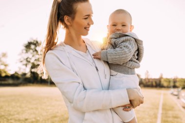 Temiz havada mutlu bir aile. Anne açık havada küçük çocuğuyla gülüp oynuyor.