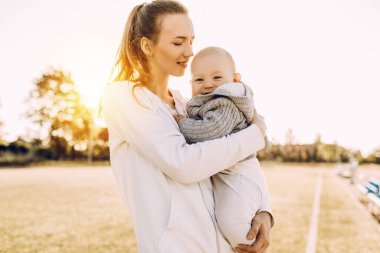 Temiz havada mutlu bir aile. Anne açık havada küçük çocuğuyla gülüp oynuyor.