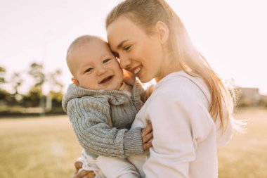 Temiz havada mutlu bir aile. Anne yazın dışarıda çocuğuyla gülüp oynuyor.