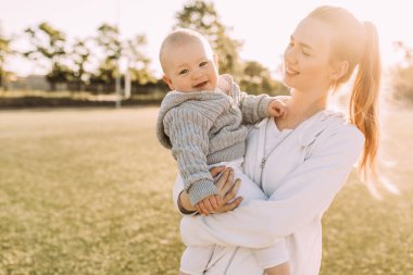 Temiz havada mutlu bir aile. Anne yazın dışarıda çocuğuyla gülüp oynuyor.