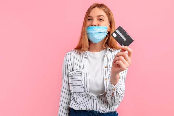 Mulher Sorrindo Uma Máscara Médica Seu Rosto Segurando Cartão Crédito — Fotografia de Stock