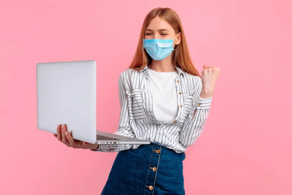 Retrato Uma Garota Animada Uma Máscara Protetora Médica Segurando Computador — Fotografia de Stock