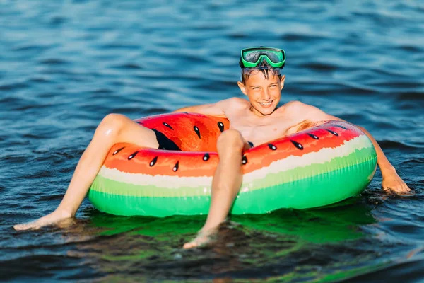 child on an inflatable circle swims on the sea, in the summer resting on the sea. A little boy has fun and swims on an inflatable circle