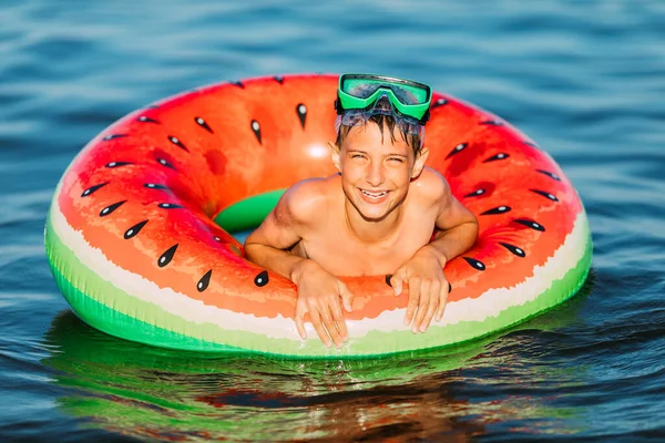 둥그렇게 둥그렇게 아이는 여름에 바다에서 수영을 소년은 재미를 느끼고 부풀어 — 스톡 사진