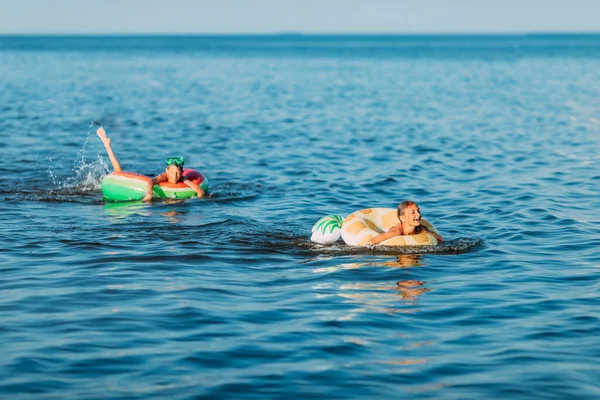 Szczęśliwe Dzieci Pływanie Morzu Nadmuchiwanymi Kółkami Zabawa Plaży Podczas Wakacji — Zdjęcie stockowe