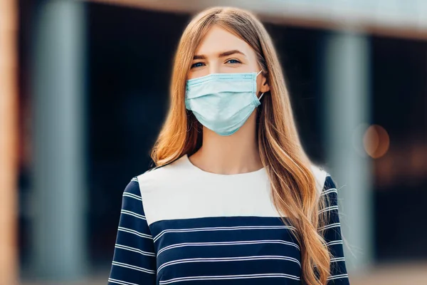 若い魅力的な若い女性医療保護マスクの彼女の顔には 市内の建物の背景に立っている 隔離コロナウイルス — ストック写真