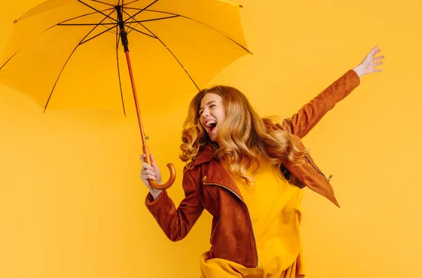 드레스와 재킷을 배경에 우산을 점프하는 — 스톡 사진
