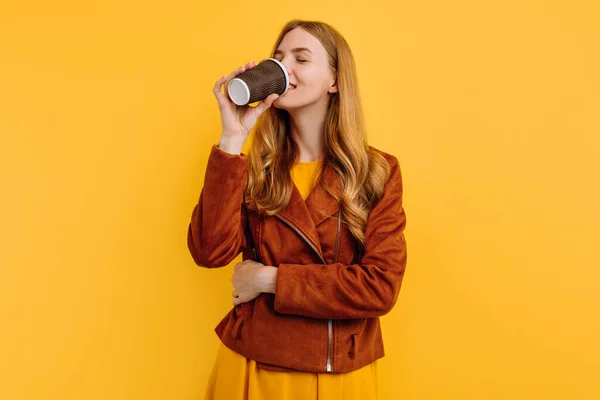 재킷을 매력적 소녀가 배경의 종이컵에서 커피를 마시는 — 스톡 사진
