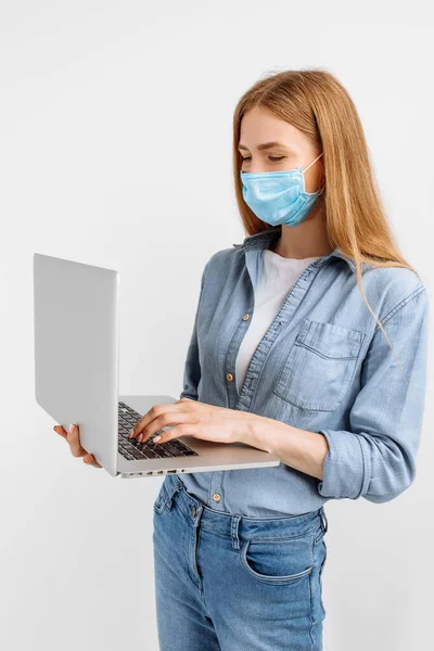 Fiatal Orvosi Maszkban Arcán Dolgozik Egy Laptop Fehér Alapon — Stock Fotó
