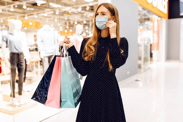 ショッピングバッグを手にした幸せな若い女性がショッピングセンターを歩いています — ストック写真