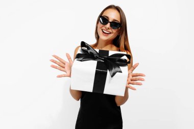 Heyecanlı genç kadın, beyaz arka planda hediye kutusu olan zarif siyah elbise içinde, alışveriş konsepti, tatil, Kara Cuma