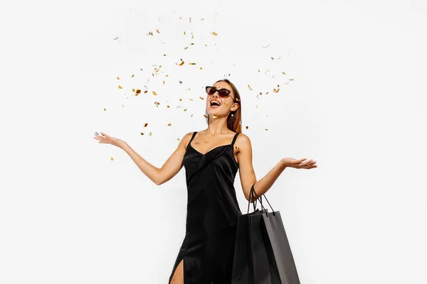 Aufgeregte Junge Frau Schwarzem Kleid Mit Einkaufstüten Feiert Und Wirft — Stockfoto
