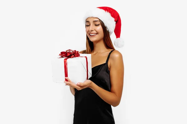 Cheerful Attractive Brunette Red Christmas Hat Black Dress Holding Gift — Stock Photo, Image