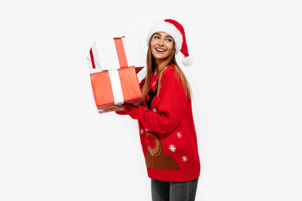 스웨터를 여성과 클라우스 모자를 여성이 배경에 선물을 있습니다 크리스마스 컨셉트 — 스톡 사진