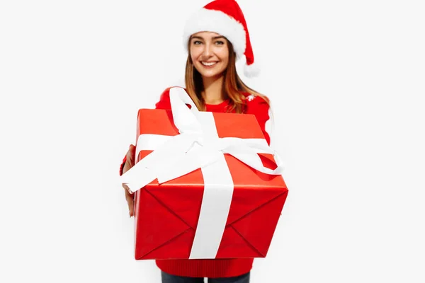 Junge Frau Weihnachtspullover Und Weihnachtsmannmütze Mit Einem Weihnachtsgeschenk Auf Weißem — Stockfoto