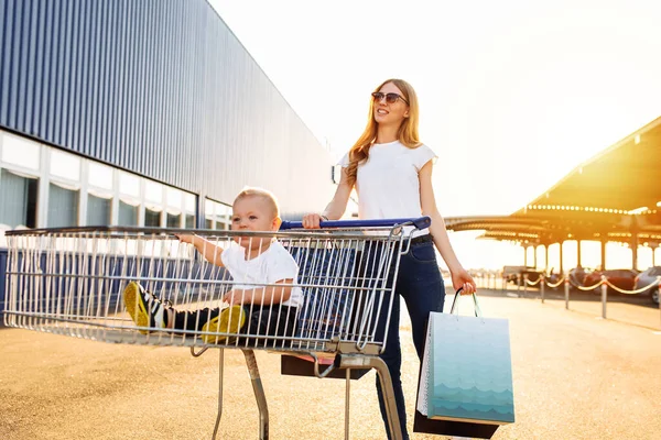 Mamma Felice Con Borse Della Spesa Con Bambino Nel Carrello — Foto Stock