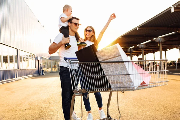 Familia Feliz Con Niño Con Bolsas Compras Carrito Compras Calle — Foto de Stock