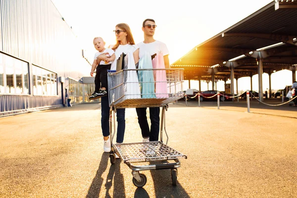 Famiglia Felice Con Bambino Con Shopping Bag Carrello Sullo Sfondo — Foto Stock