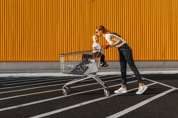 Attraktiv Glad Ung Kvinna Solglasögon Shopping Med Små Barn Vagn — Stockfoto